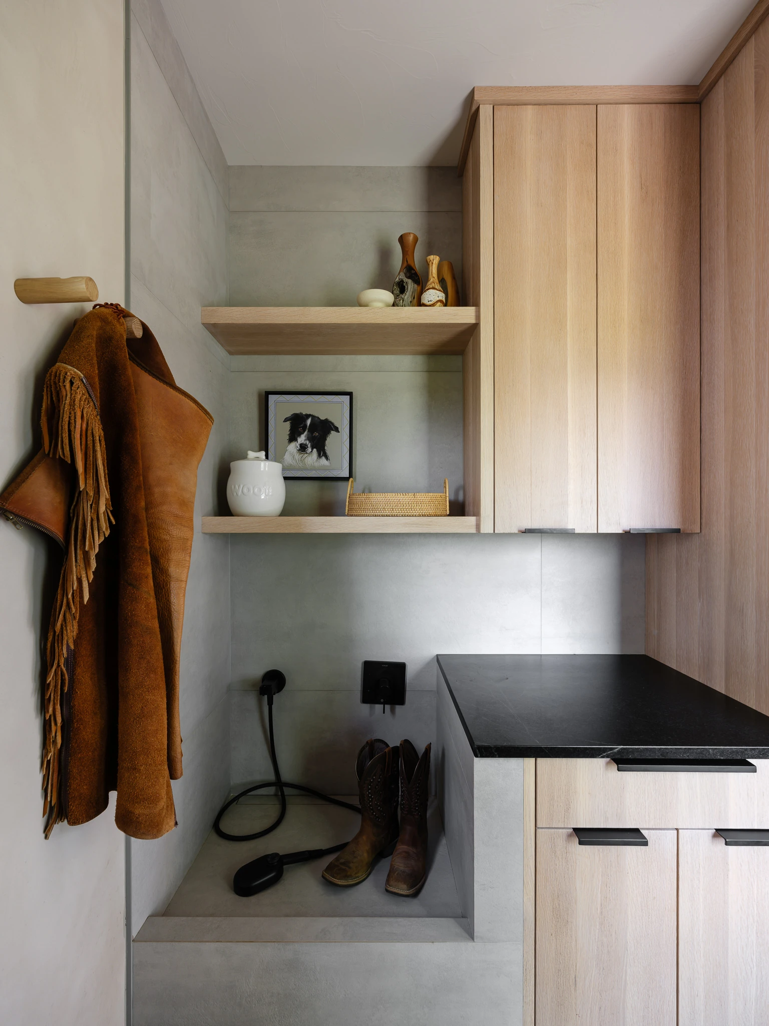Mudroom with boot bench and leather jacket on hooks — Dry Creek Ranch, Design Republic Interiors; Southwest Montana editorial interior photography